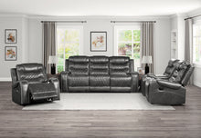 Gray reclining sofa set in a living room with large windows.