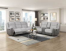 Gray sofa in a living room with large windows and modern decor.