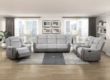 Gray sofa set in a living room with large windows and decor.