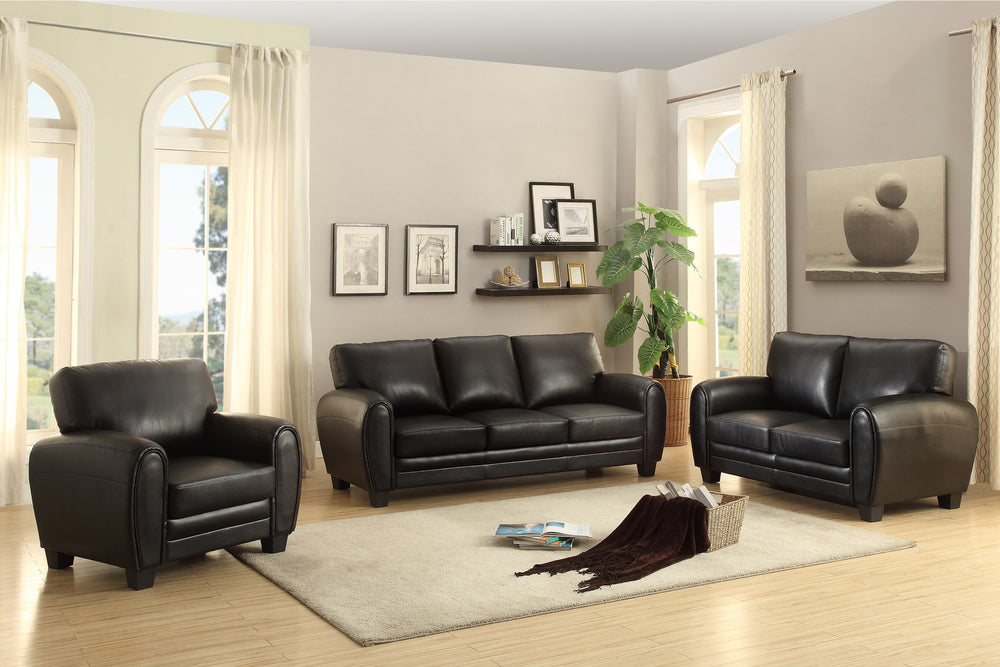 Black sofa set in a living room with decor elements.