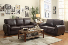 Living room with brown sofa set and decorative elements.