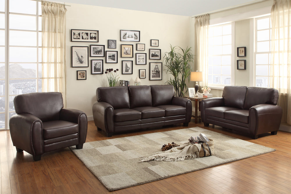 Living room with brown furniture and framed pictures on the wall.